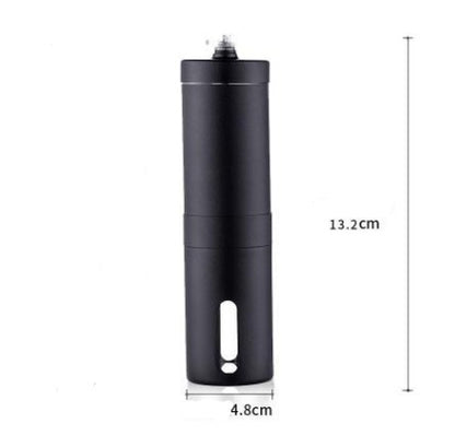 Stainless steel hand coffee grinder beside roasted coffee beans