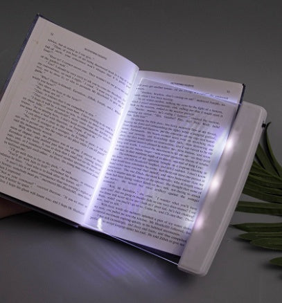 Dimmable LED reading lamp illuminating an open book for comfortable night reading
